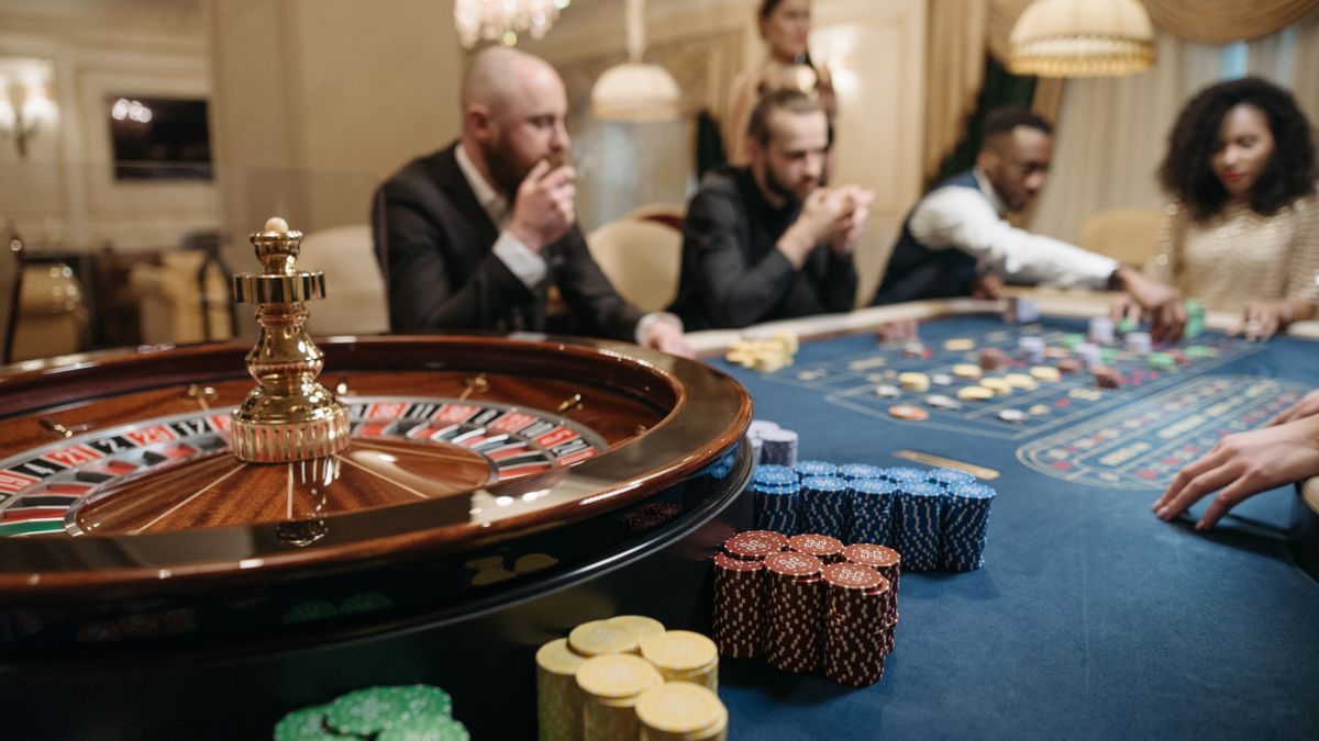 Meja roulette di kasino dengan dealer dan pemain