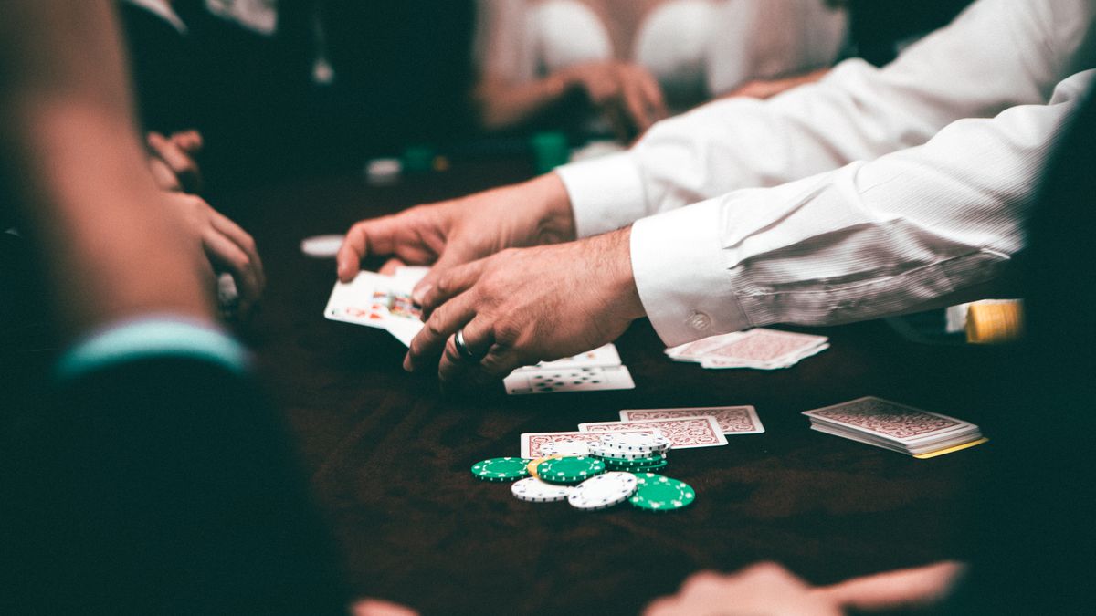 Pemain poker berkumpul di meja dengan tumpukan kartu dan chip