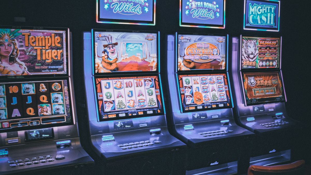 Barisan mesin slot bercahaya di lantai kasino