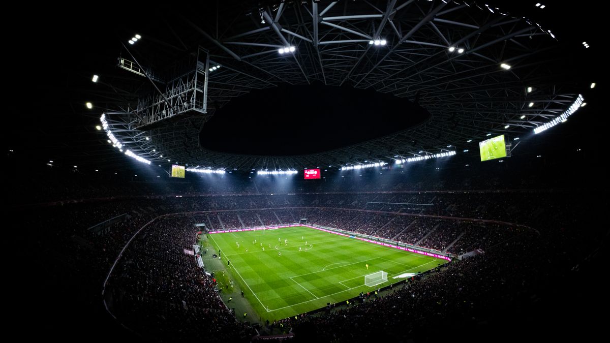Pertandingan sepak bola malam hari di stadion yang menyala